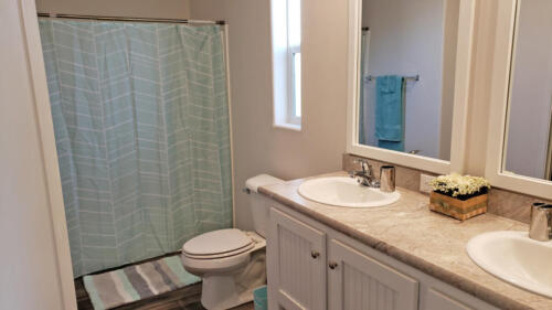 A bathroom with two sinks and a shower curtain.